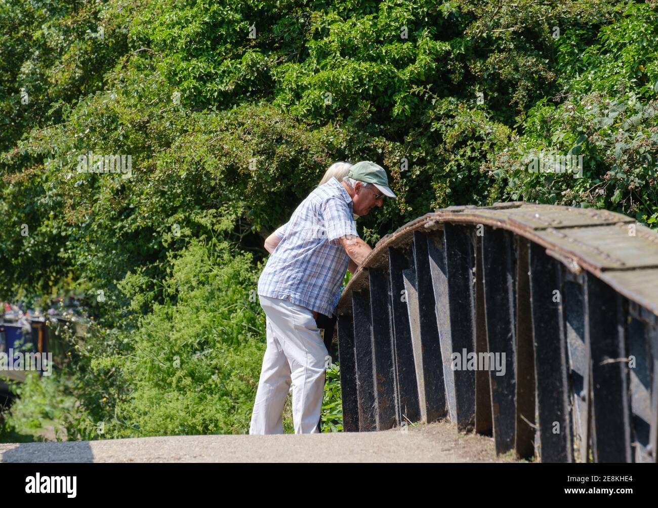 An elderly man leans on the railing on the side of the Grand Union