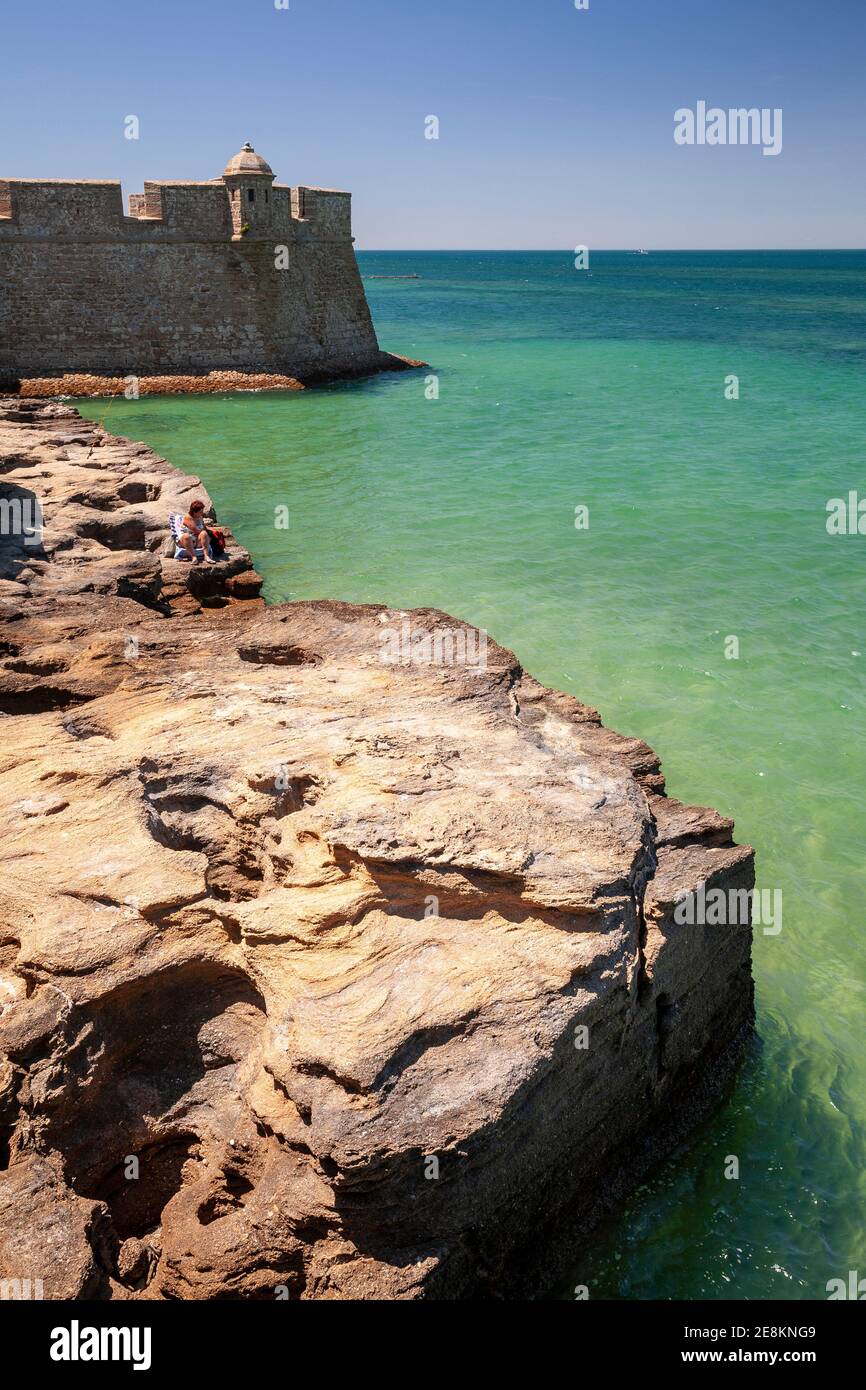 Tourist on rocks by the sea at Cadiz, Spain Stock Photo