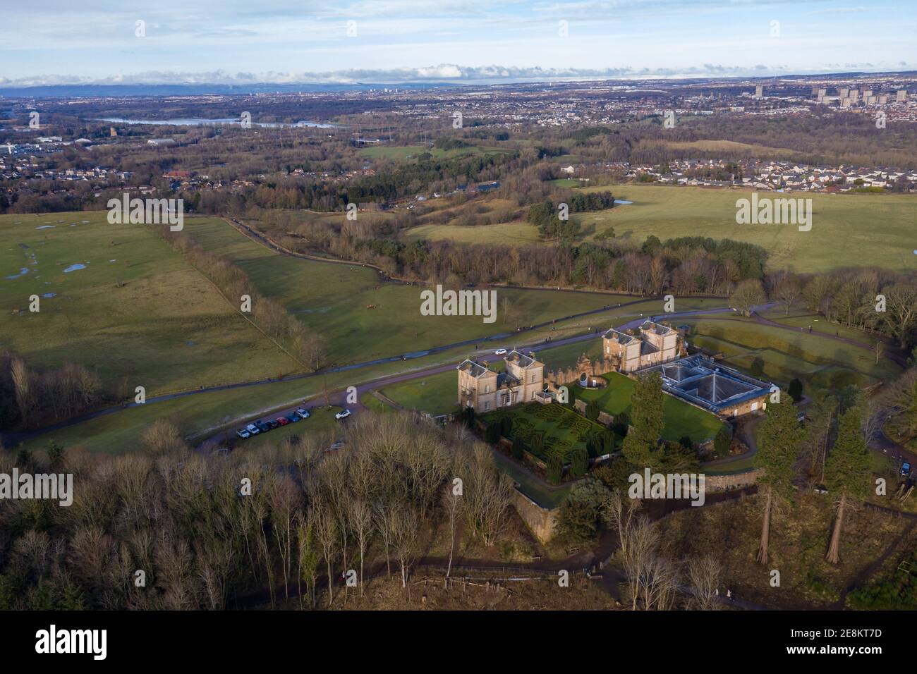 Hamilton, Scotland, UK. 31st Jan, 2021. Pictured: Aerial drone photography showing Chatelherault Country Park and the backdrop of Hamilton and Glasgow. The sun is out and people are enjoying themselves during the coronavirus phase 4 lockdown. Temperatures are around 2 degrees with temperatures expected to fall overnight again with some freezing conditions. Calm and very sunny with blue skies. Credit: Colin Fisher/Alamy Live News Stock Photo