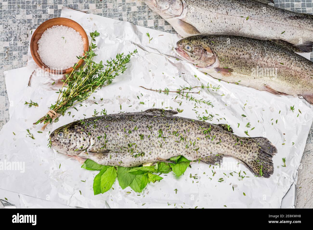 Preparing fresh whole trout for grilling in summer garden Stock Photo