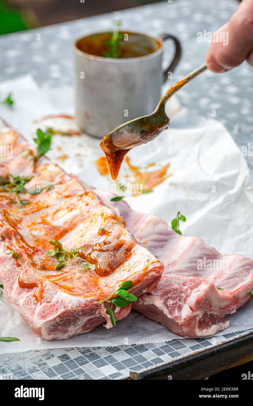 Preparing ribs with marinade and spices for summer grilling in garden ...
