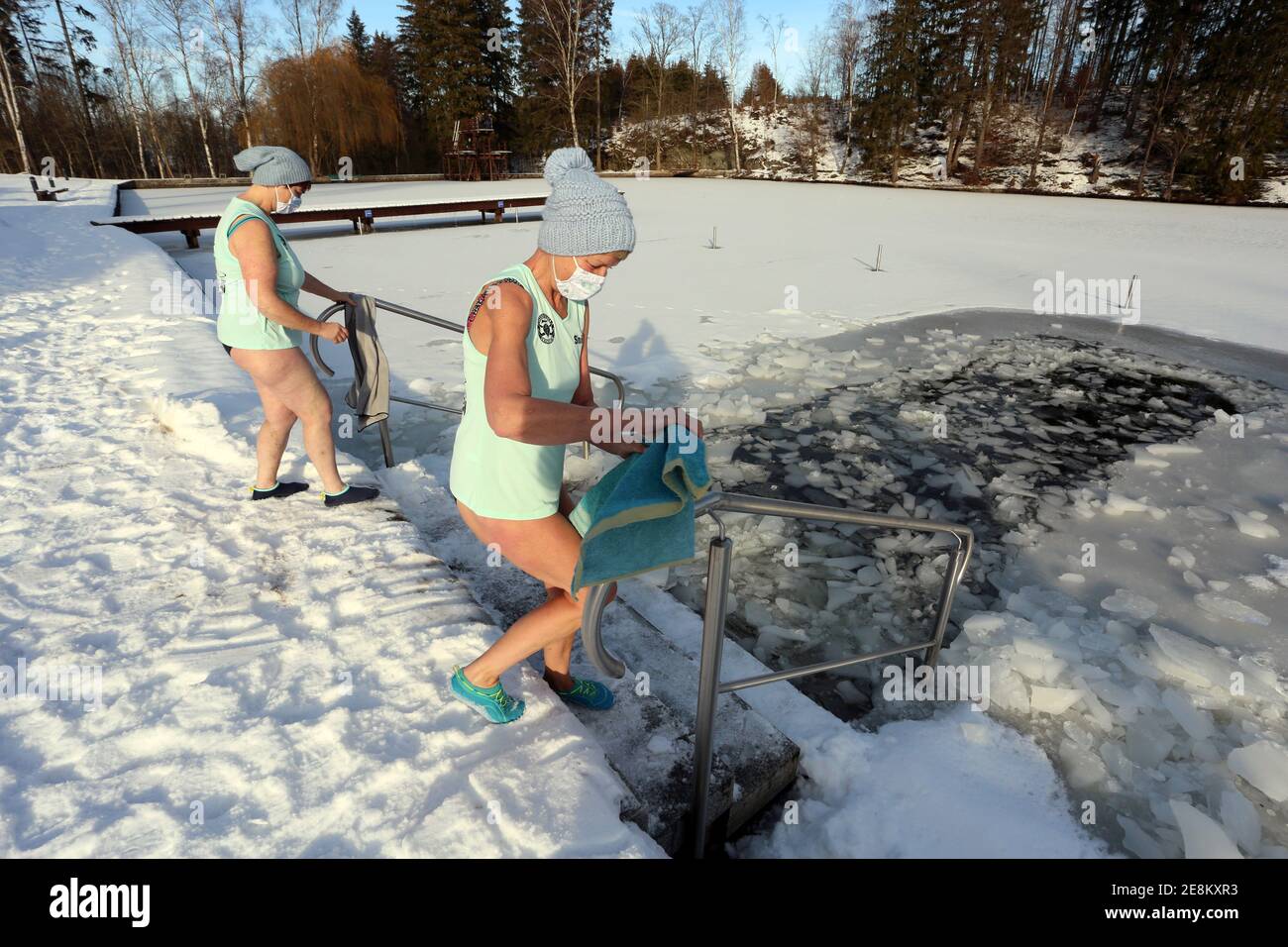Hasselfelde, Germany. 31st Jan, 2021. Two women get into the icy water in  the Waldseebad. For six years, the women and men of the Hasselfelder  Eisperlen have been meeting weekly for ice