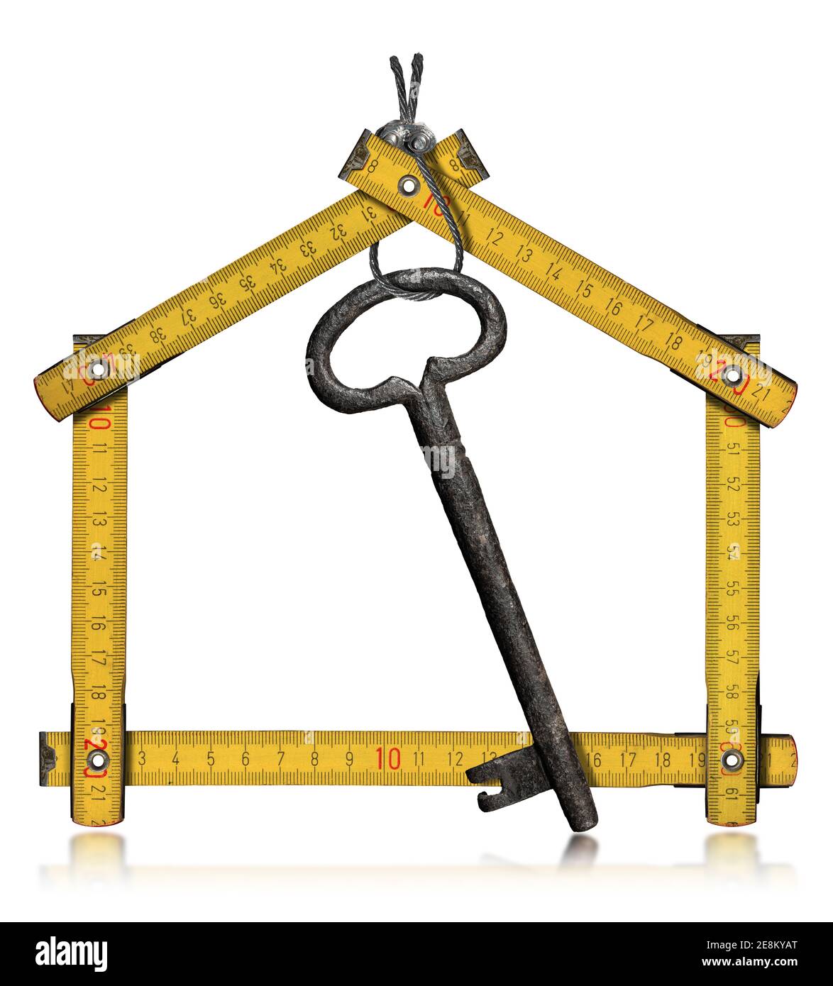 Folding ruler in the shape of a house with an old key hanging. Isolated