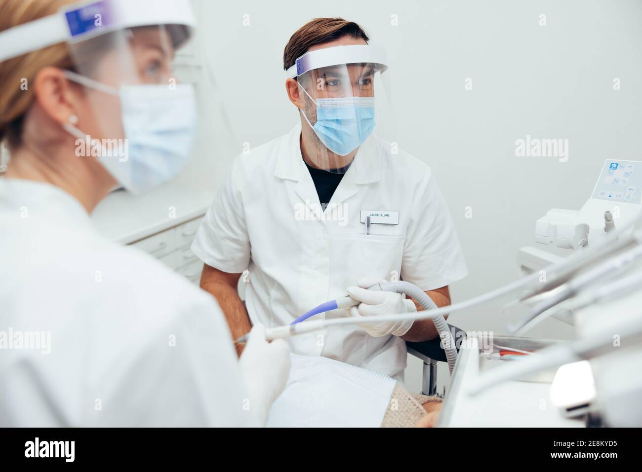 Dental doctors wearing face shields and masks during dental treatment