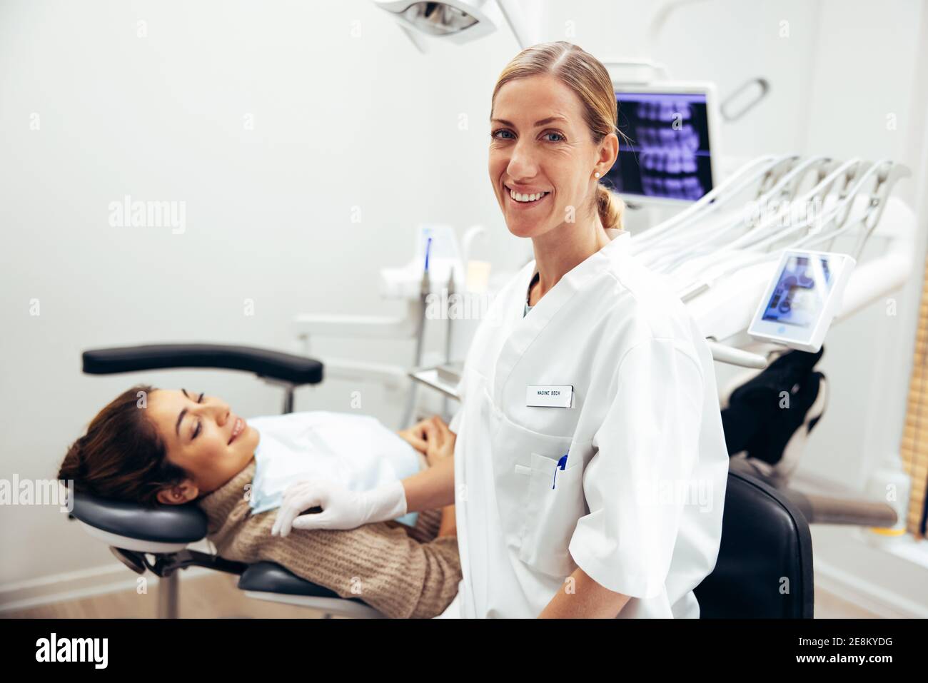 Successful female dentist in her clinic. Dental expert with female patient at dentistry. Stock Photo