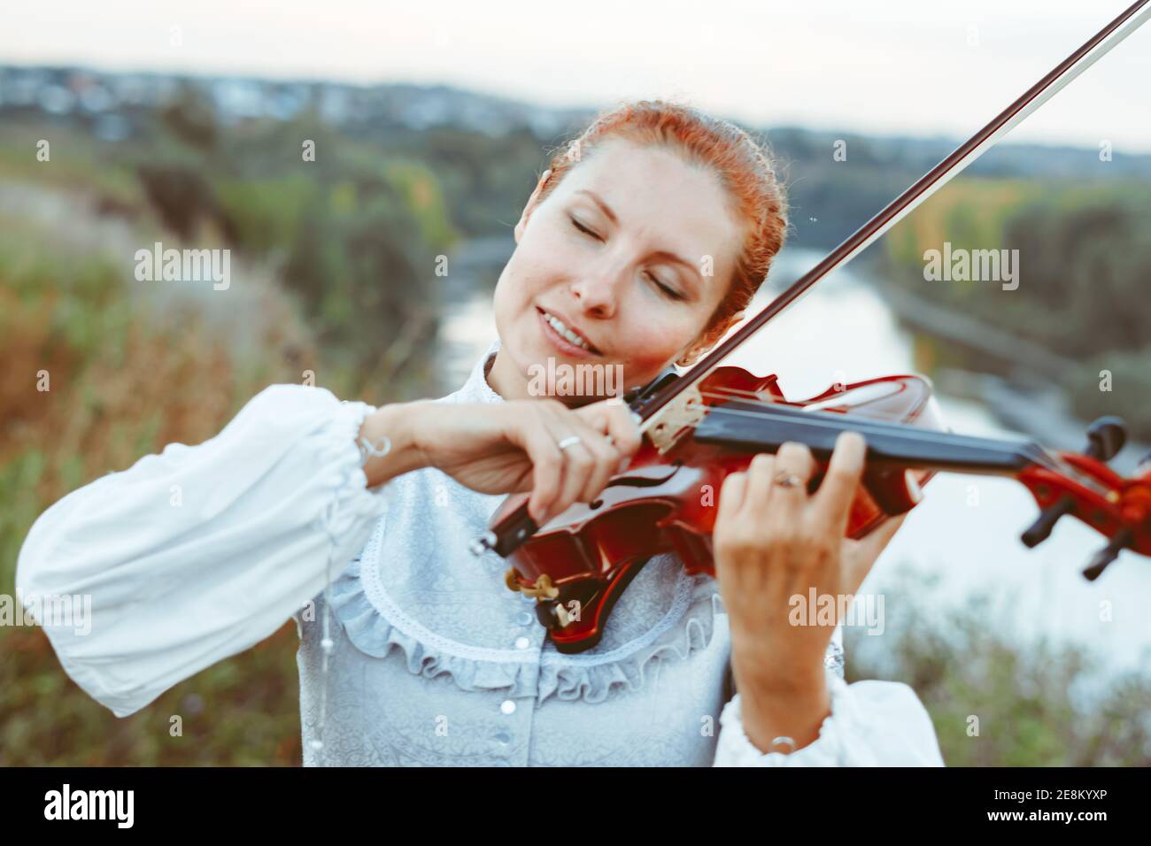 beautiful girl playing violin in white dress in forest Stock Photo - Alamy