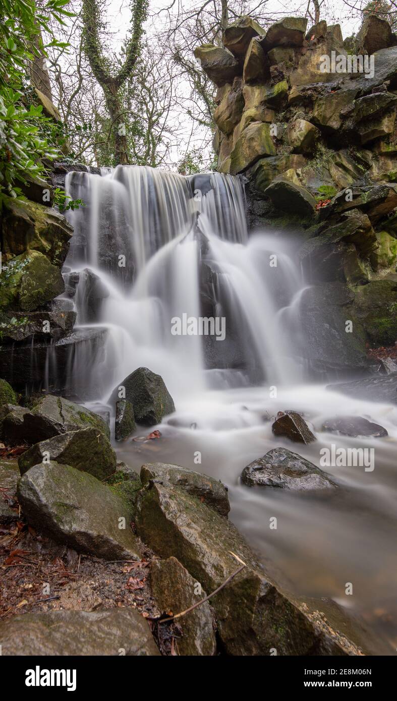 Chorlton Brook cascading over the rocks of the waterfall after heavy rain at Abney Hall Park, Cheadle, Stockport, Greater Manchester Stock Photo