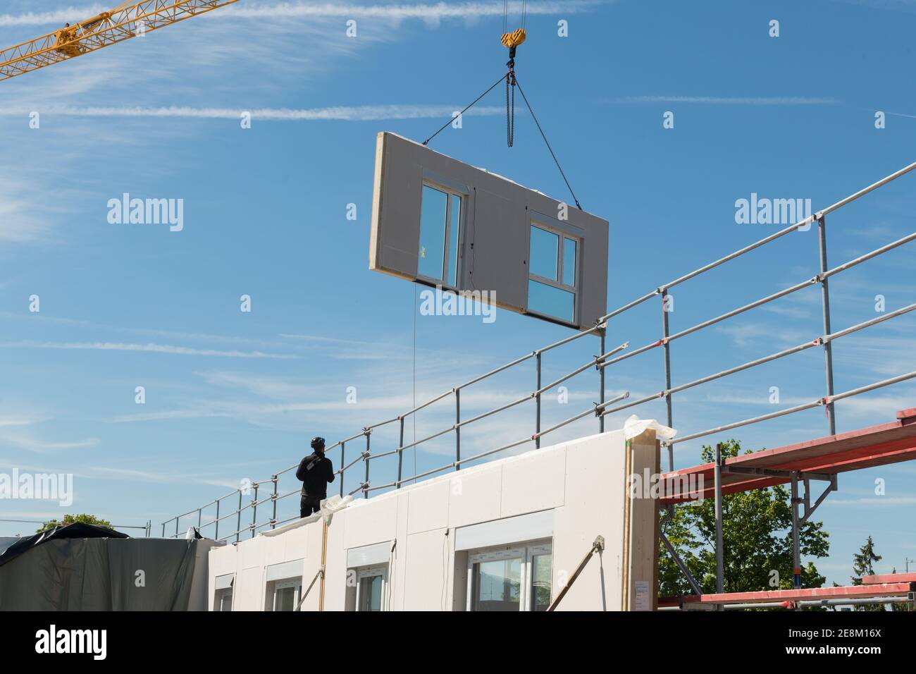 Montage eines Modularen Wohnbaus. Einschweben von Wandteile per Kran. Stock Photo