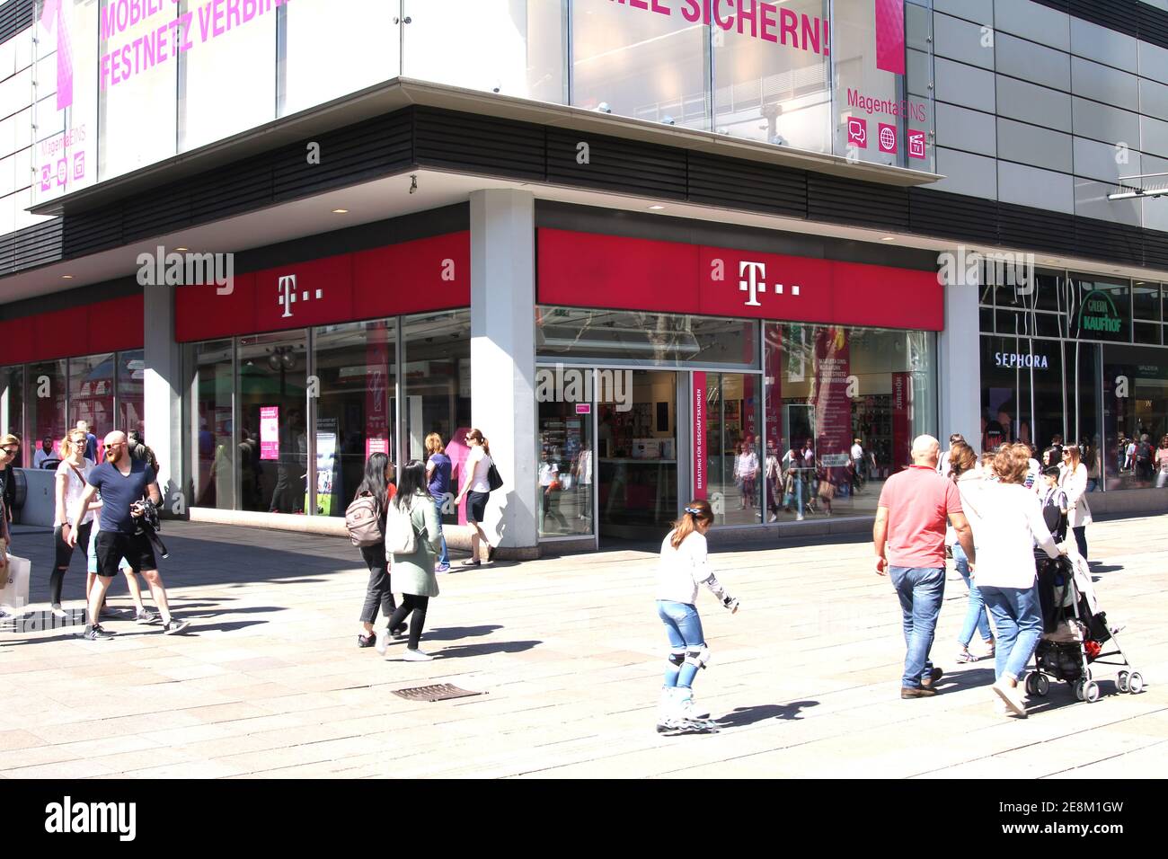 T-Mobile store with people. T-Mobile is the brand name used by the mobile communications subsidiaries of the German telecommunications company Stock Photo