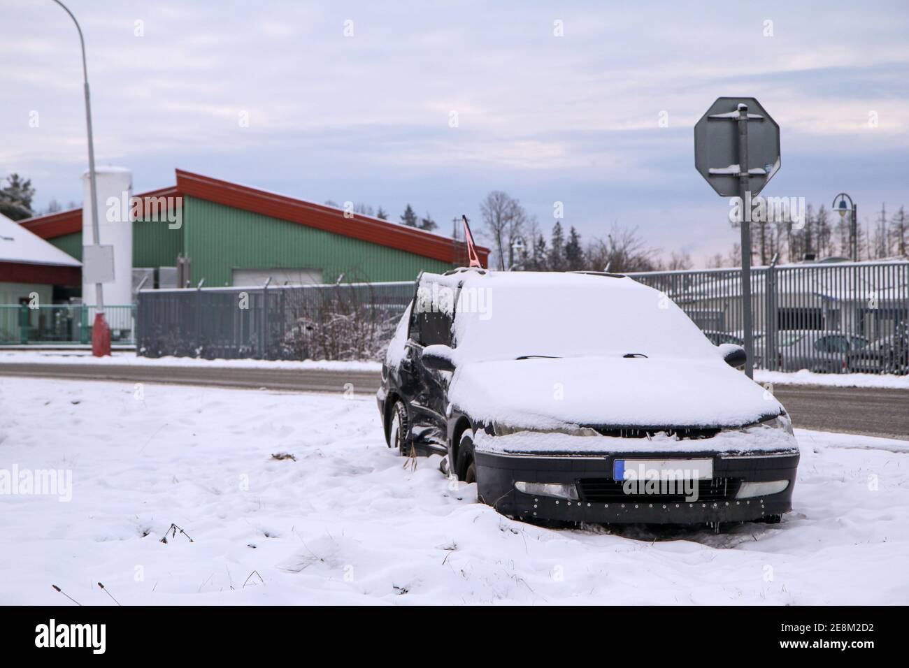 Abandoned car in the ditch after the traffic accident. The driver didn´t give way to the other car. Covered by snow. Stock Photo