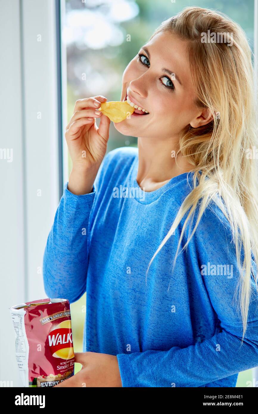 Girl eating a bag of crisps Stock Photo