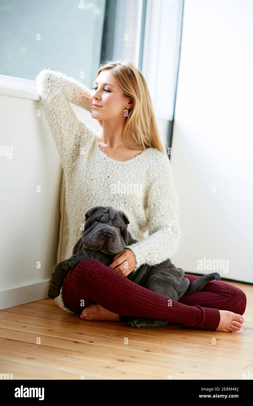 Beautiful blonde woman sat with her dog Stock Photo