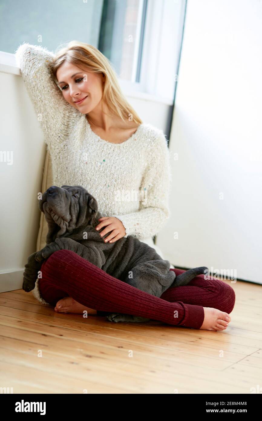 Beautiful blonde woman sat with her dog Stock Photo