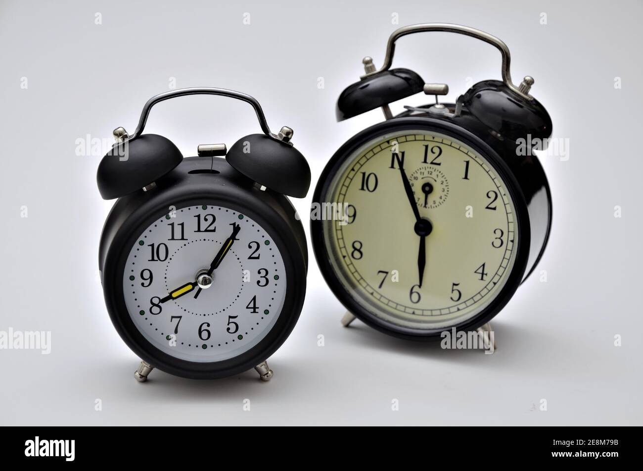 close up of two black retro alarm clocks with twin bells, showing