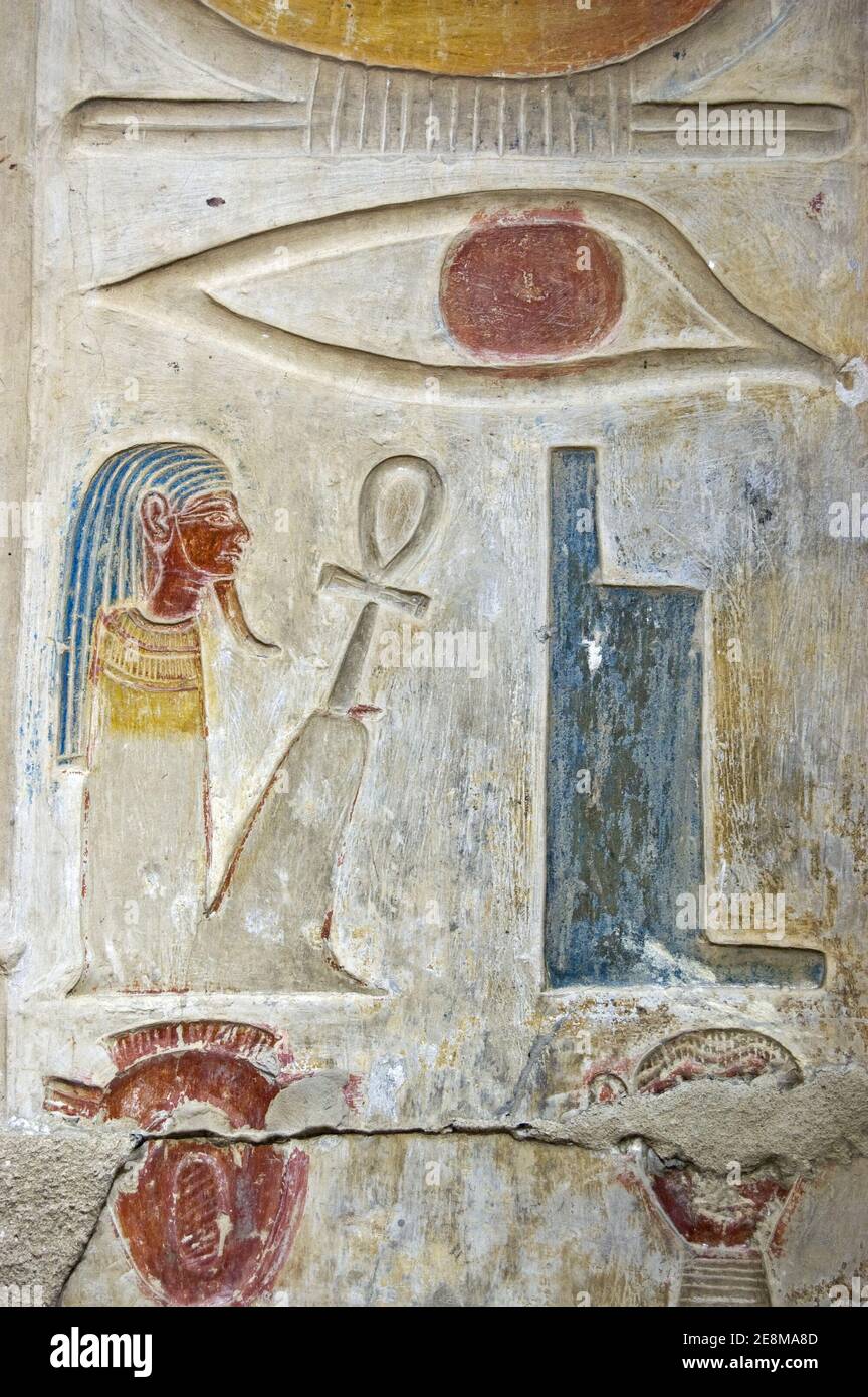 Ancient Egyptian hieroglyphs carved on a wall of Abydos Temple near el Balyana, Egypt. An eye, throne, squatting pharaoh and two heads.  Ancient carvi Stock Photo