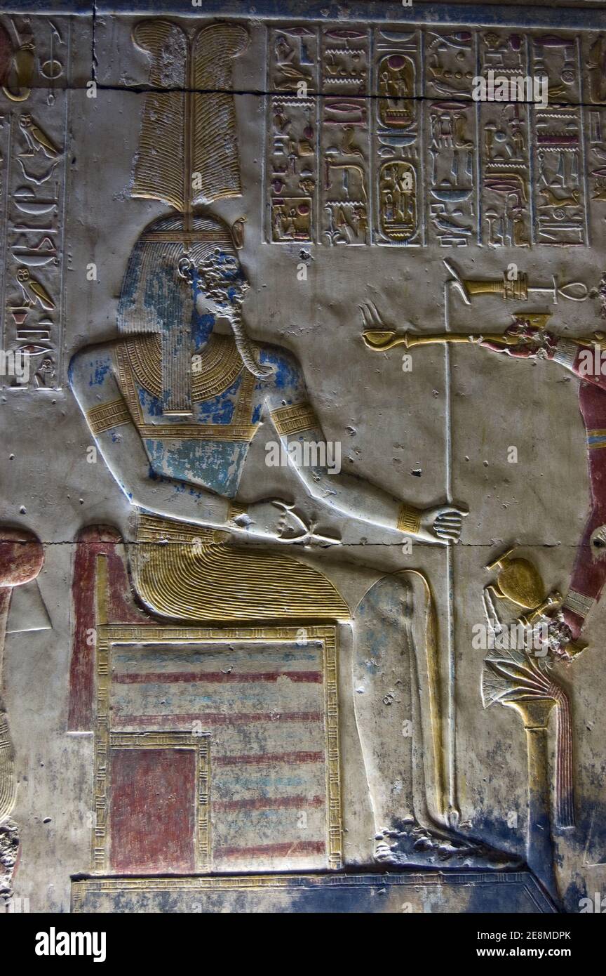 Bas relief carving of the ancient Egyptian god Amun. Coloured blue with a headdress of ostrich feathers. Wall of Abydos Temple, near el Balyana, Egypt Stock Photo