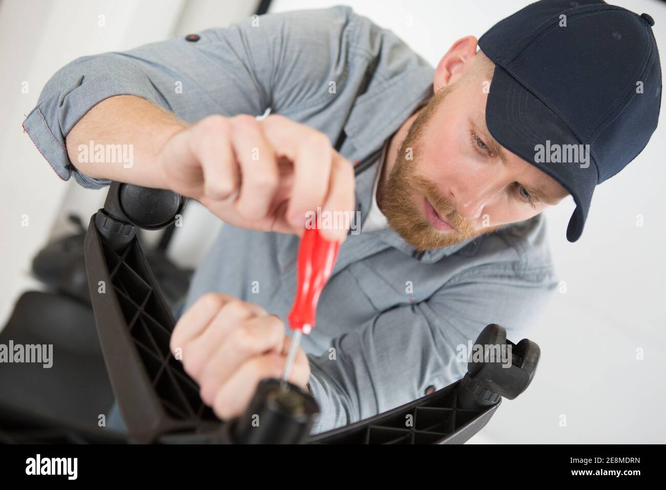 man assembles new office chair Stock Photo