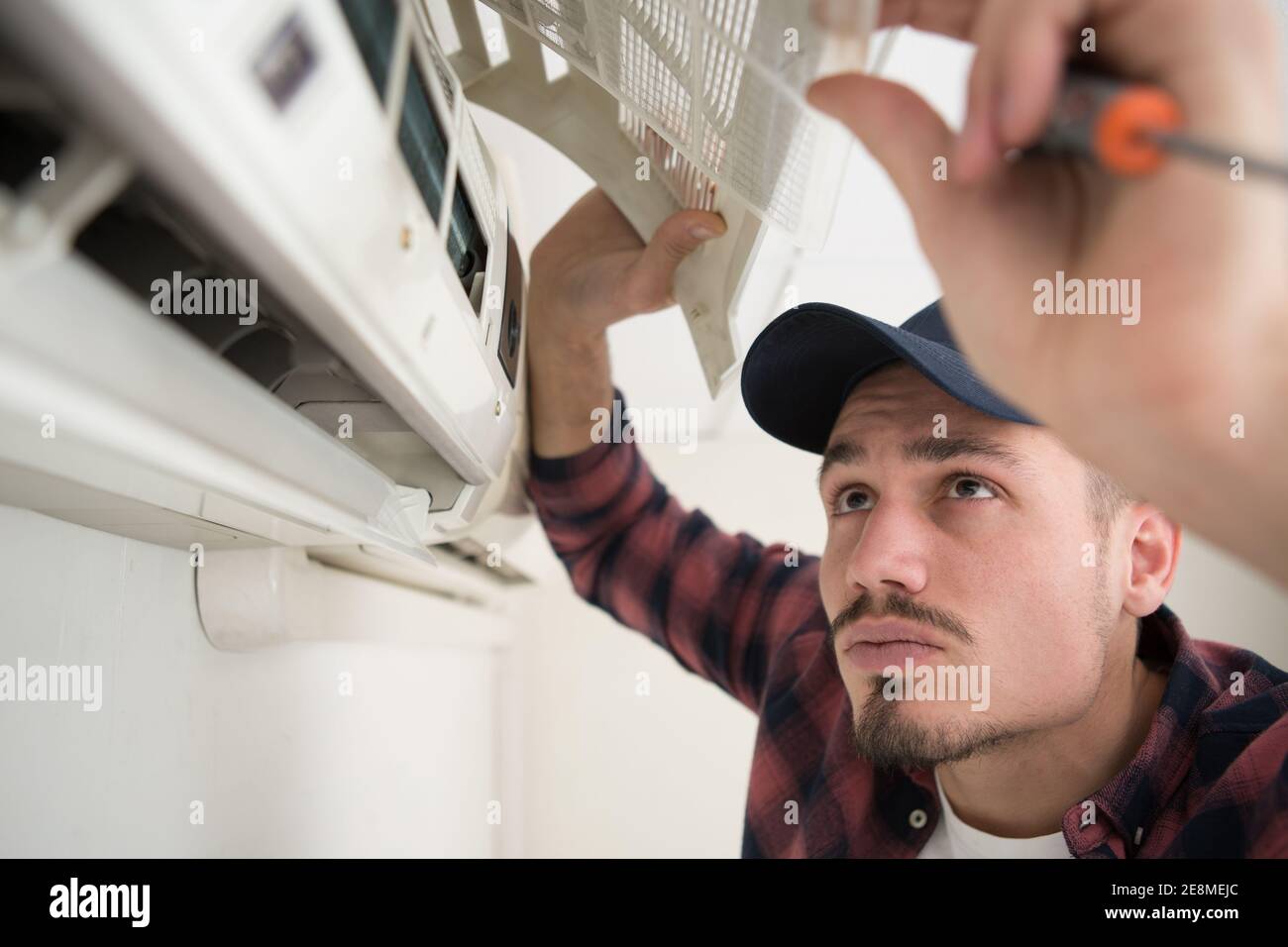 concentrated man is fixing air conditioning Stock Photo Alamy