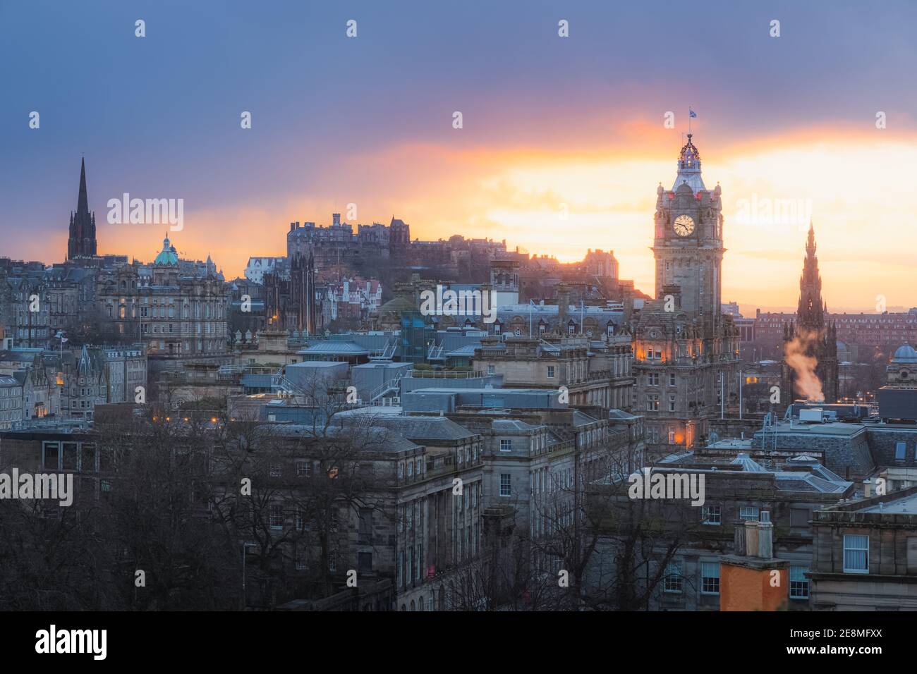 Classic cityscape view of Edinburgh old town skyline, Balmoral Clock Tower and Edinburgh Castle from Calton Hill with a dramatic sunset in the capital Stock Photo