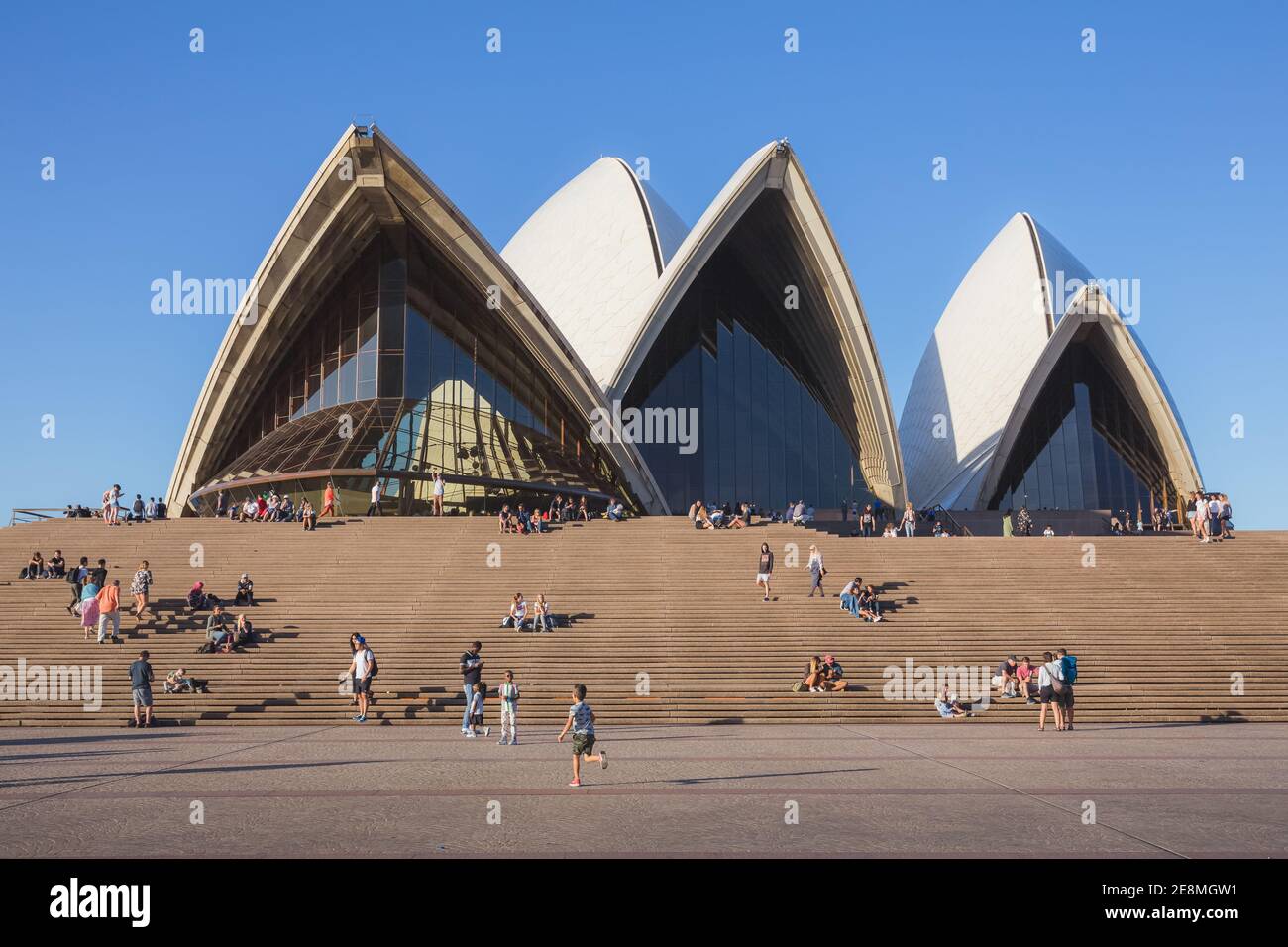 Sydney, Australia - January 4 2018: Tourists and visitors gather on the steps in front of the unique and modern architecture of the iconic Sydney Oper Stock Photo