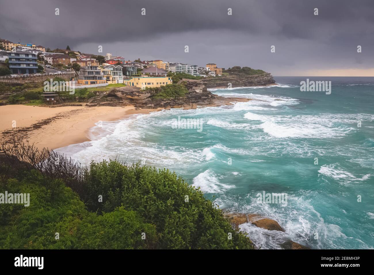 View over Tamarama Beach bay against a moody, stormy sky with whitecaps on a summer day along the Bondi to Bronte coastal walk in Sydney, NSW. Stock Photo
