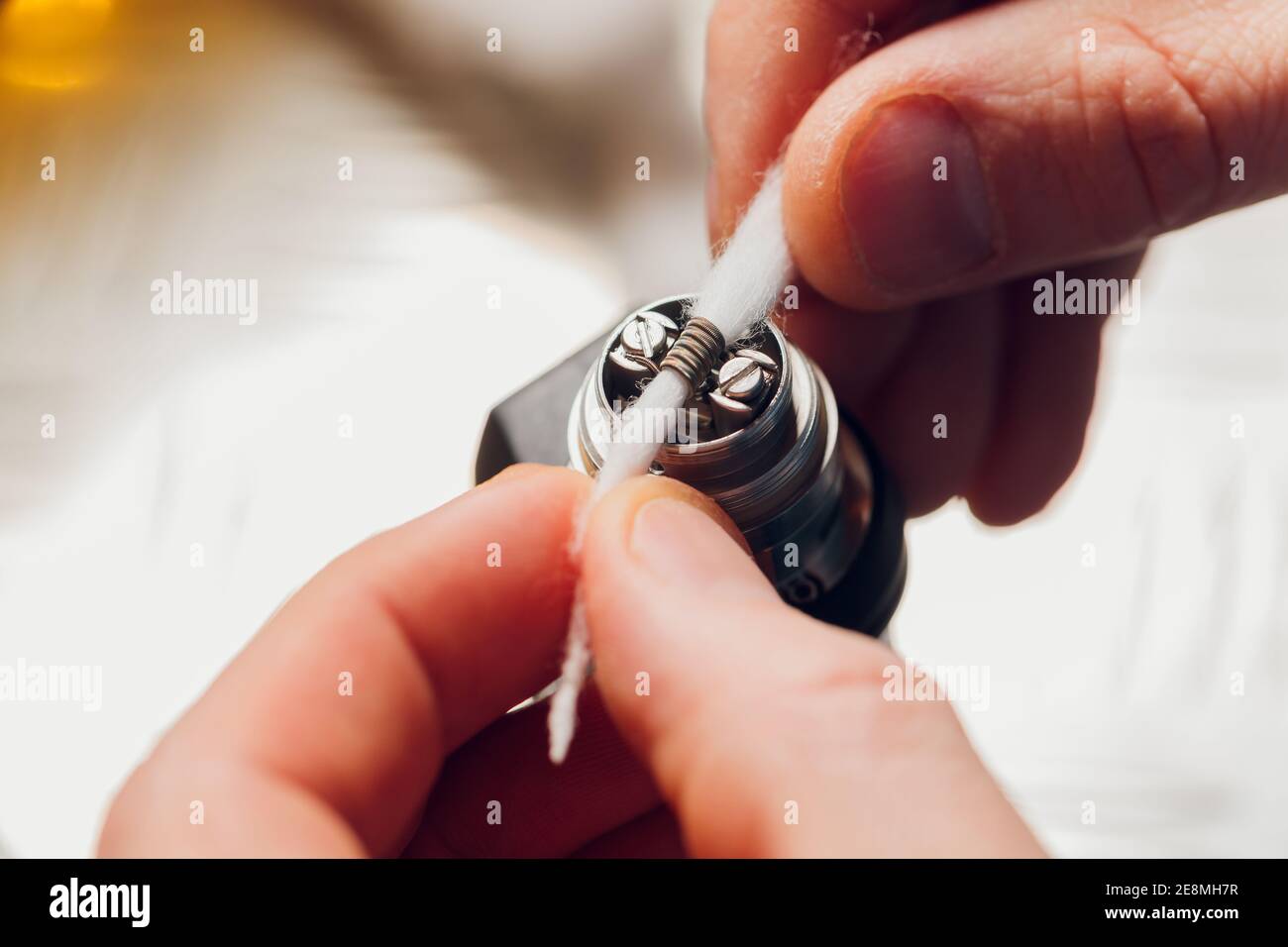 Specialist replaces spring for smoking vape.Professional maintaining  electronic cigarette in shop.Fix broken vaping device and quit smoking  nicotine c Stock Photo