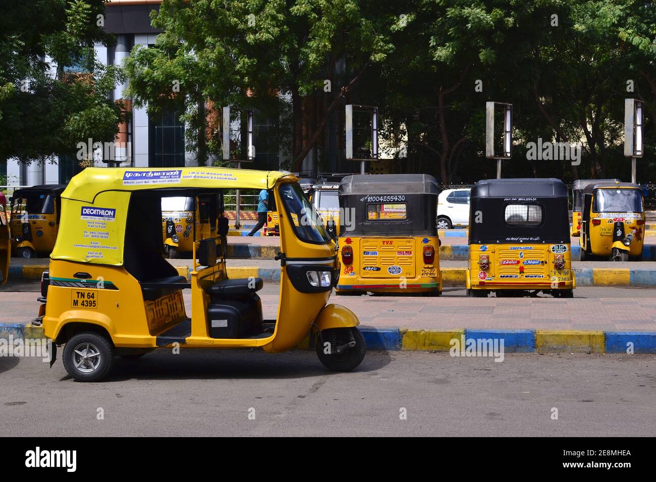 Madurai, Tamil Nadu, India - January, 2017: Auto rickshaws parked on parking lot in front of Madurai Junction railway station. Yellow tuk-tuk taxi Stock Photo