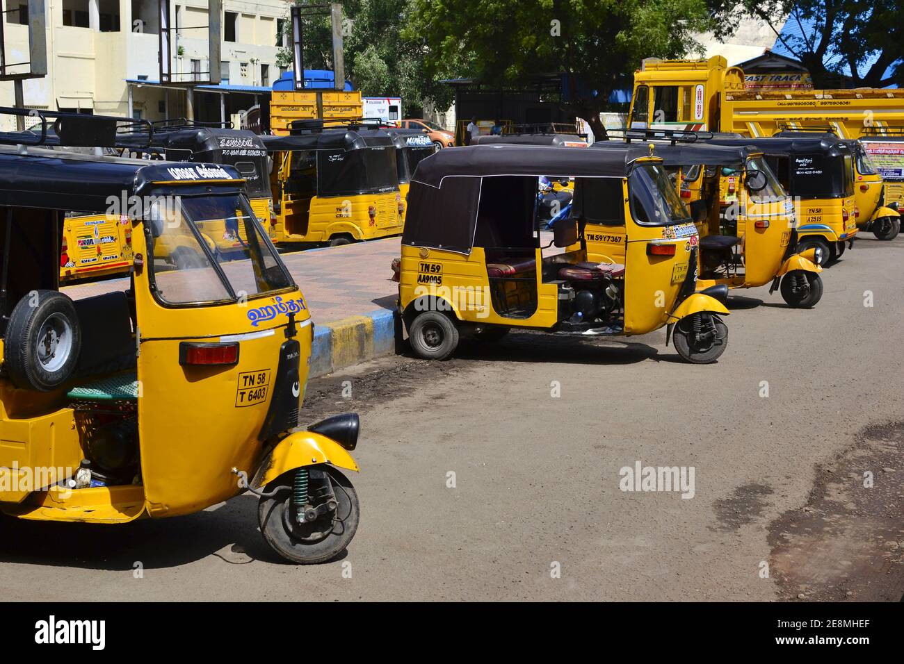 Madurai, Tamil Nadu, India - January, 2017: Auto rickshaws parked on parking lot in front of Madurai Junction railway station. Yellow tuk-tuk taxi wai Stock Photo