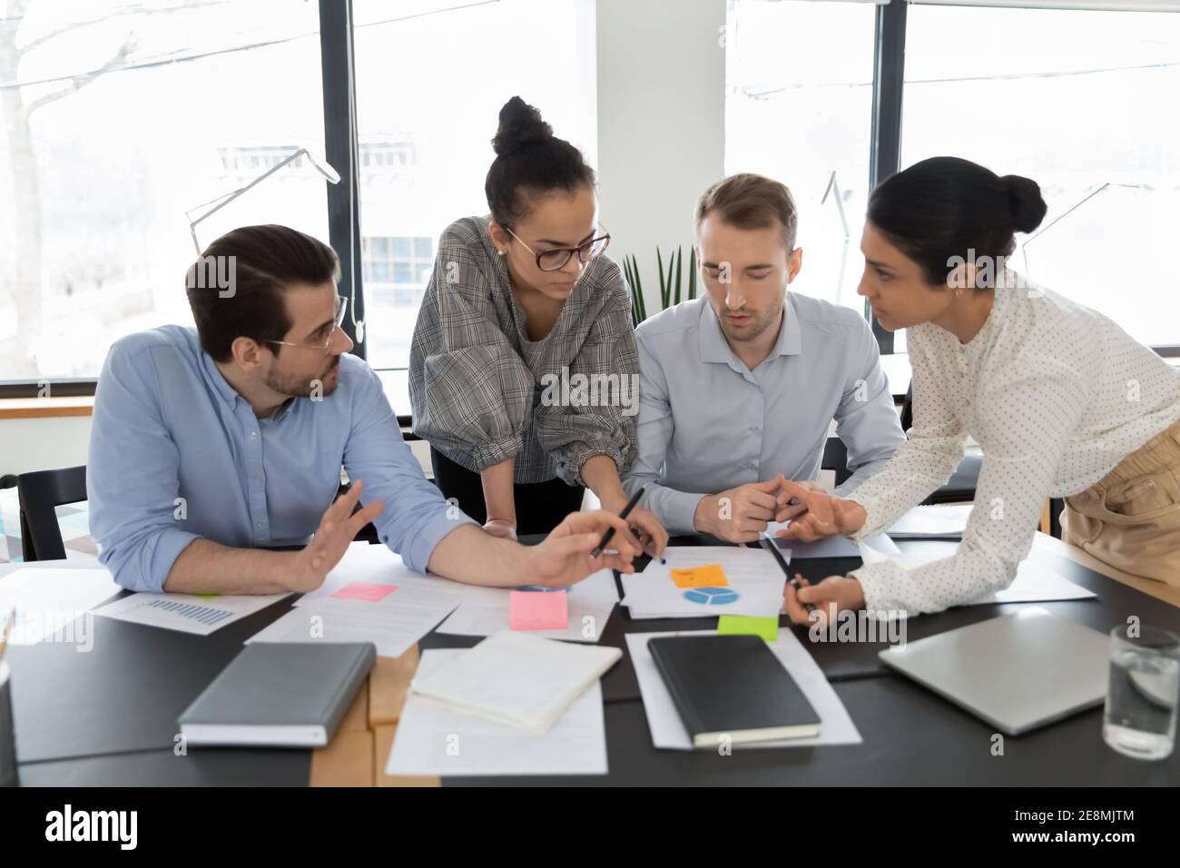 Multiethnic team of colleagues brainstorming over documents Stock Photo