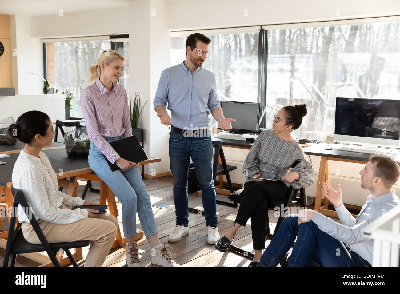 Business coaches teaching diverse team of interns Stock Photo