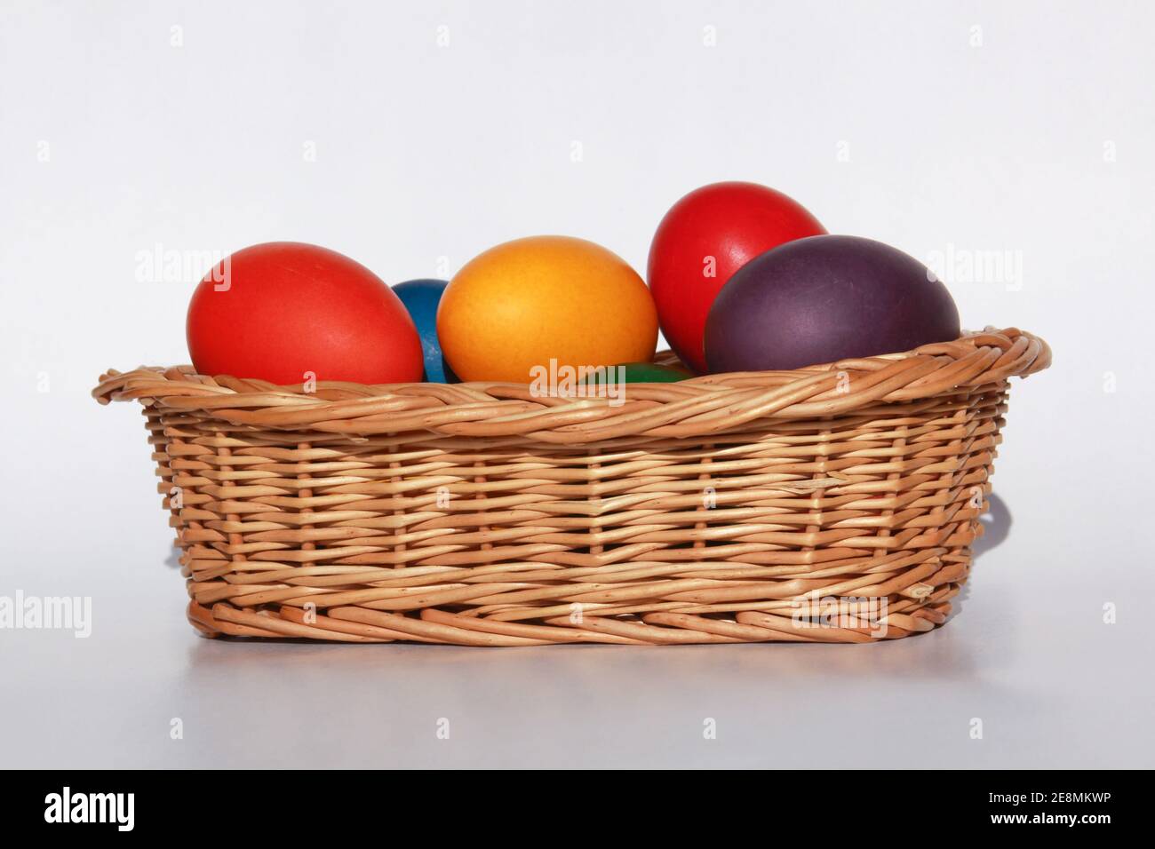 Colored painted Easter eggs in wooden basket decoration in preparation for holiday. Painting chicken or duck eggs is a Christian tradition to celebrat Stock Photo