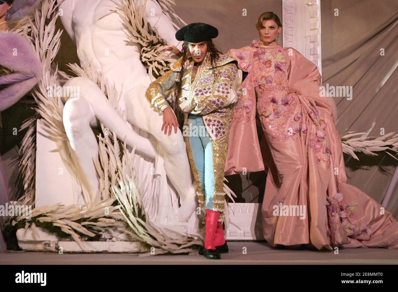 British designer John Galliano poses with a model at the end of