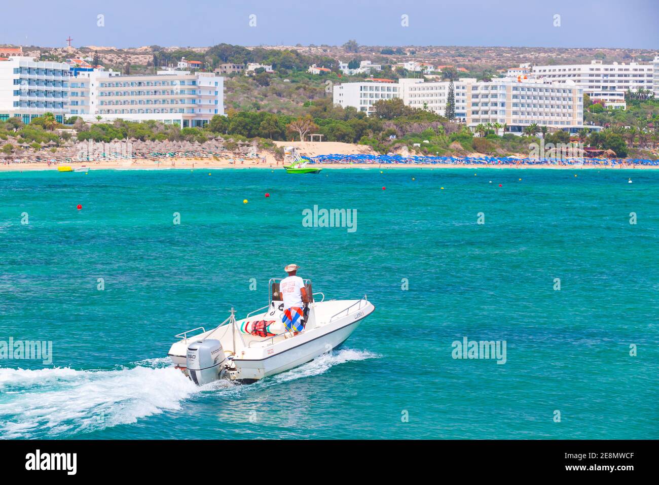 Ayia Napa, Cyprus - June 12, 2018: White pleasure motor boat with driver  goes at Agia Napa bay at sunny day, rear view Stock Photo - Alamy