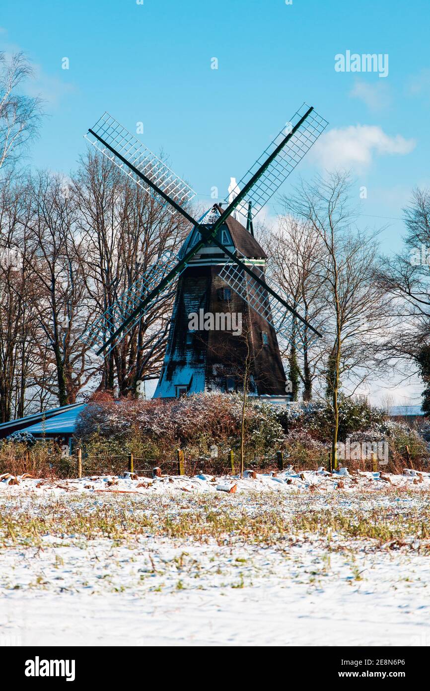 Wide-angle view of a windmill with stormy sky background.