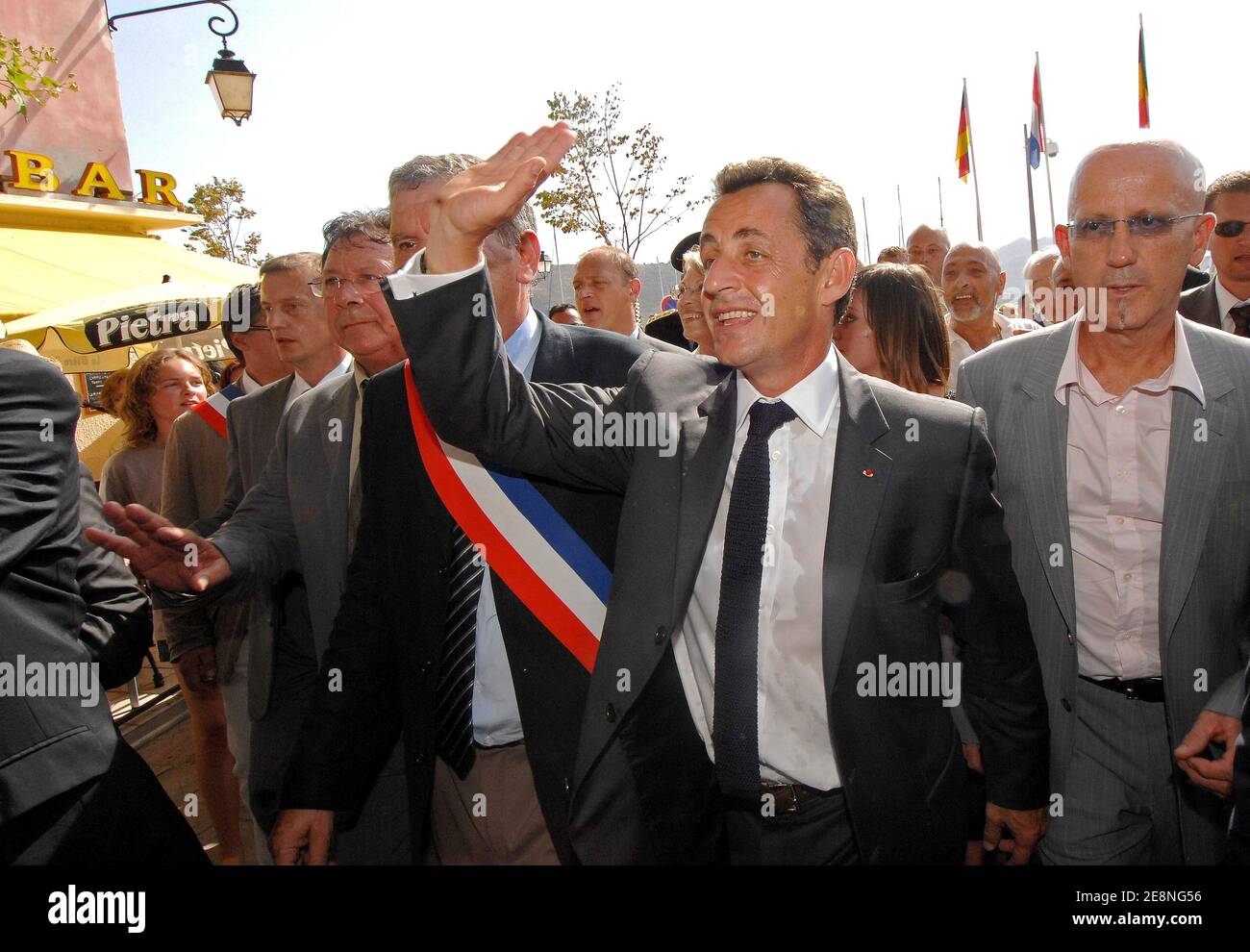 France's President Nicolas Sarkozy (L) waves to the crowd while flanked by Lucien Benvenuti (R) at Saint-Florent during a one-day visit to the French Mediterranean island of Corsica France, on August 28, 2007. Benvenuti is a local restaurant owner who claims to have received extortion threats.Photo by Christophe Guibbbaud/ABACAPRESS.COM Stock Photo