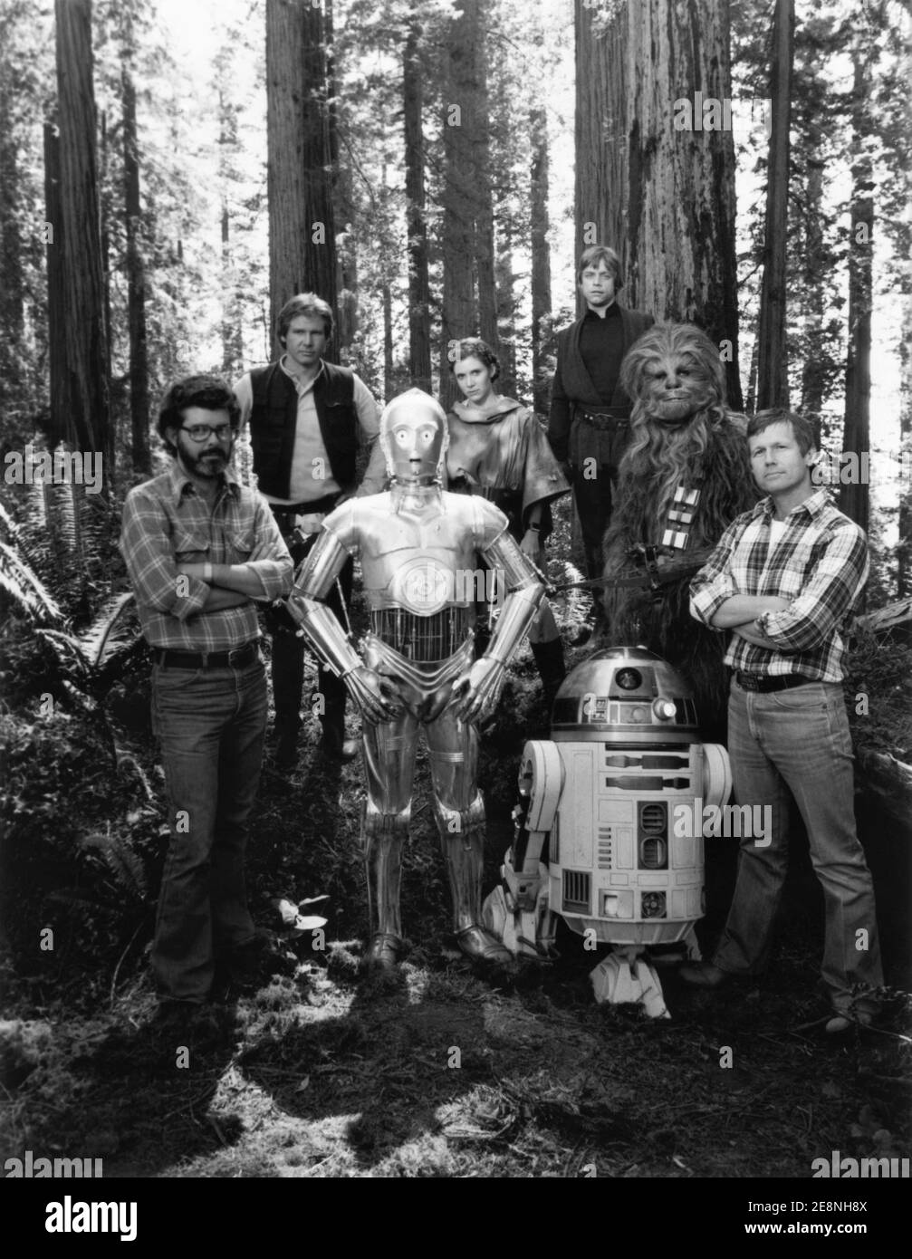 GEORGE LUCAS HARRISON FORD ANTHONY DANIELS CARRIE FISHER MARK HAMILL KENNY BAKER PETER MAYHEW and RICHARD MARQUAND on set location group portrait by Ralph Nelson Jr. during filming of STAR WARS : EPISODE VI - RETURN OF THE JEDI 1983 director RICHARD MARQUAND story George Lucas screenplay Lawrence Kasdan and George Lucas music John Williams executive producer George Lucas Lucasfilm / Twentieth Century Fox Stock Photo