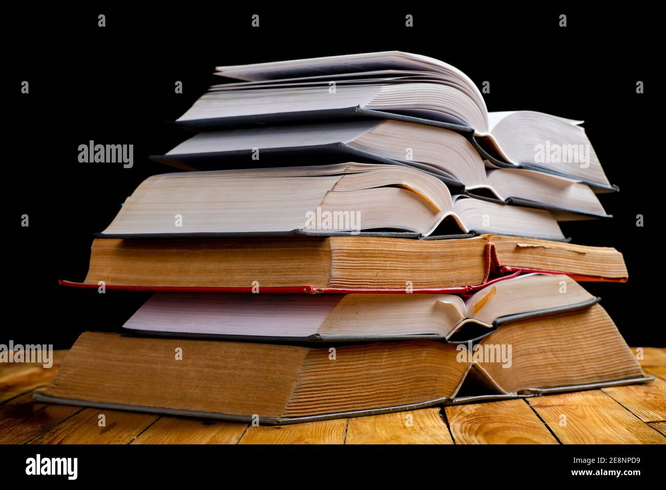 Pile of open books. A large amount of information contained in books. Dark background. Stock Photo