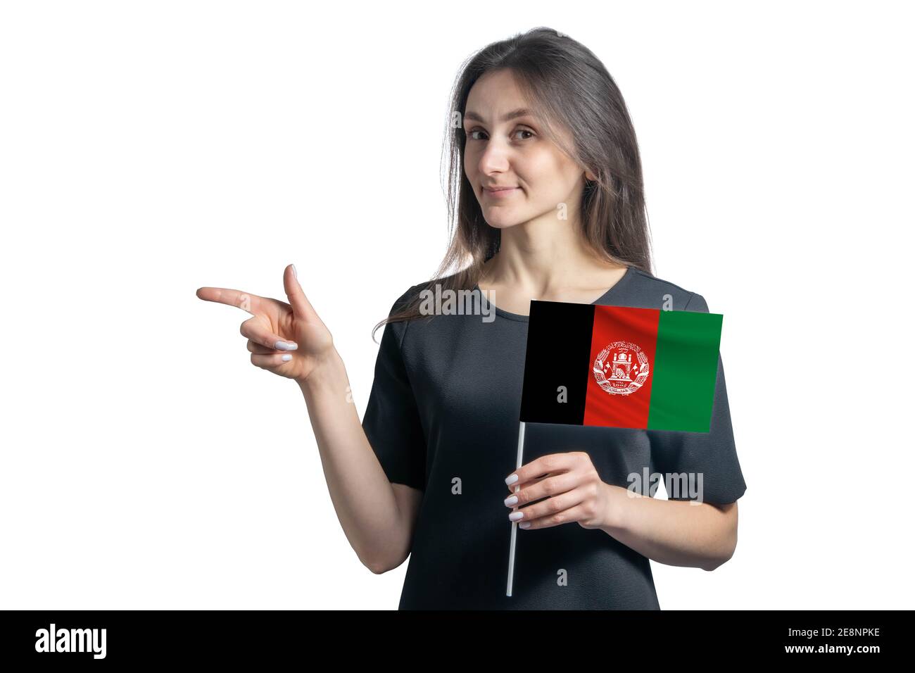 Happy young white woman holding flag Afghanistan and points to the left isolated on a white background Stock Photo