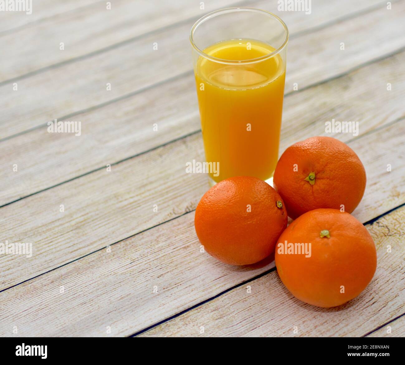 Fresh squeezed healthy orange juice and whole navel oranges close up