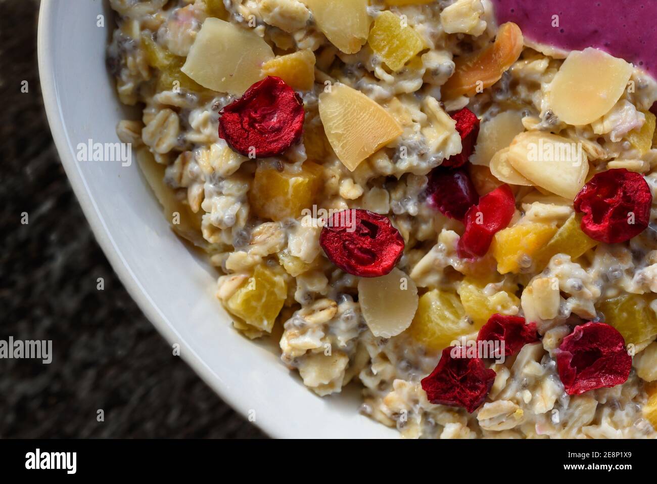 Porridge with chia seeds, almonds, orange pieces, and fruits, flat lay close-up Stock Photo