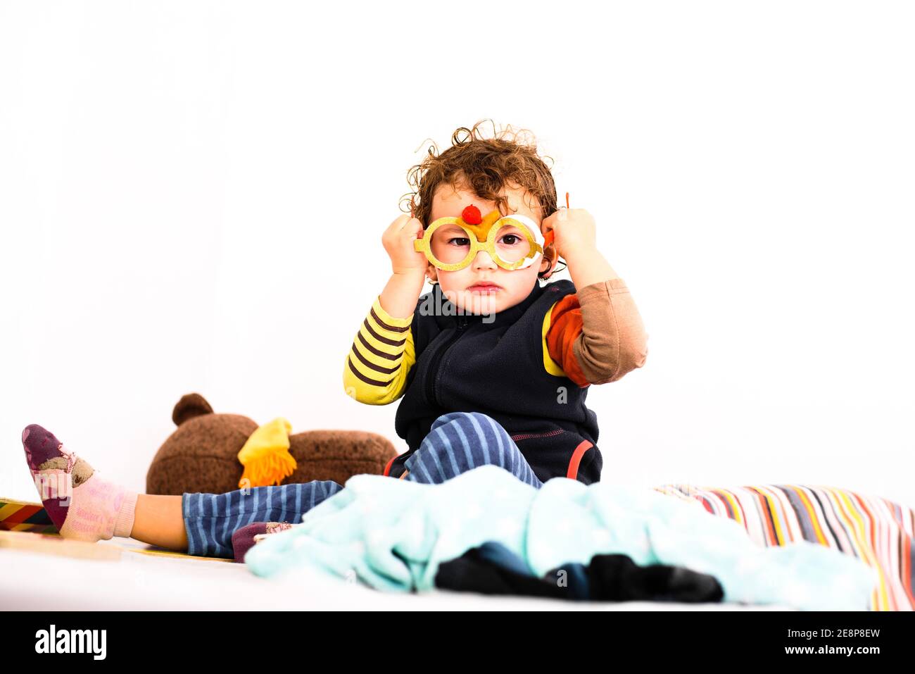 Little baby girl playing with fake glasses alone in her room