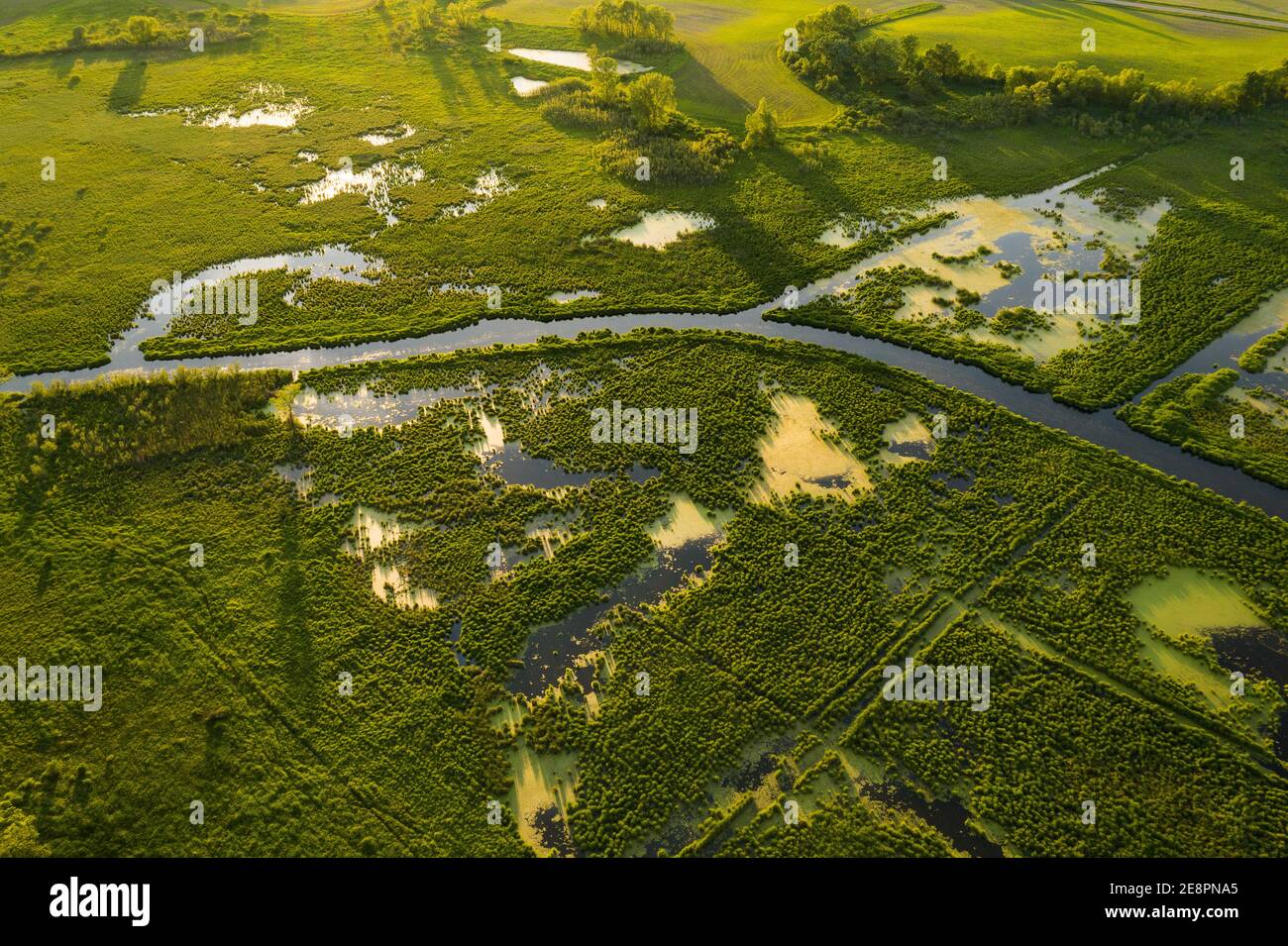 An aerial view of the river flowing through large green valleys Stock ...