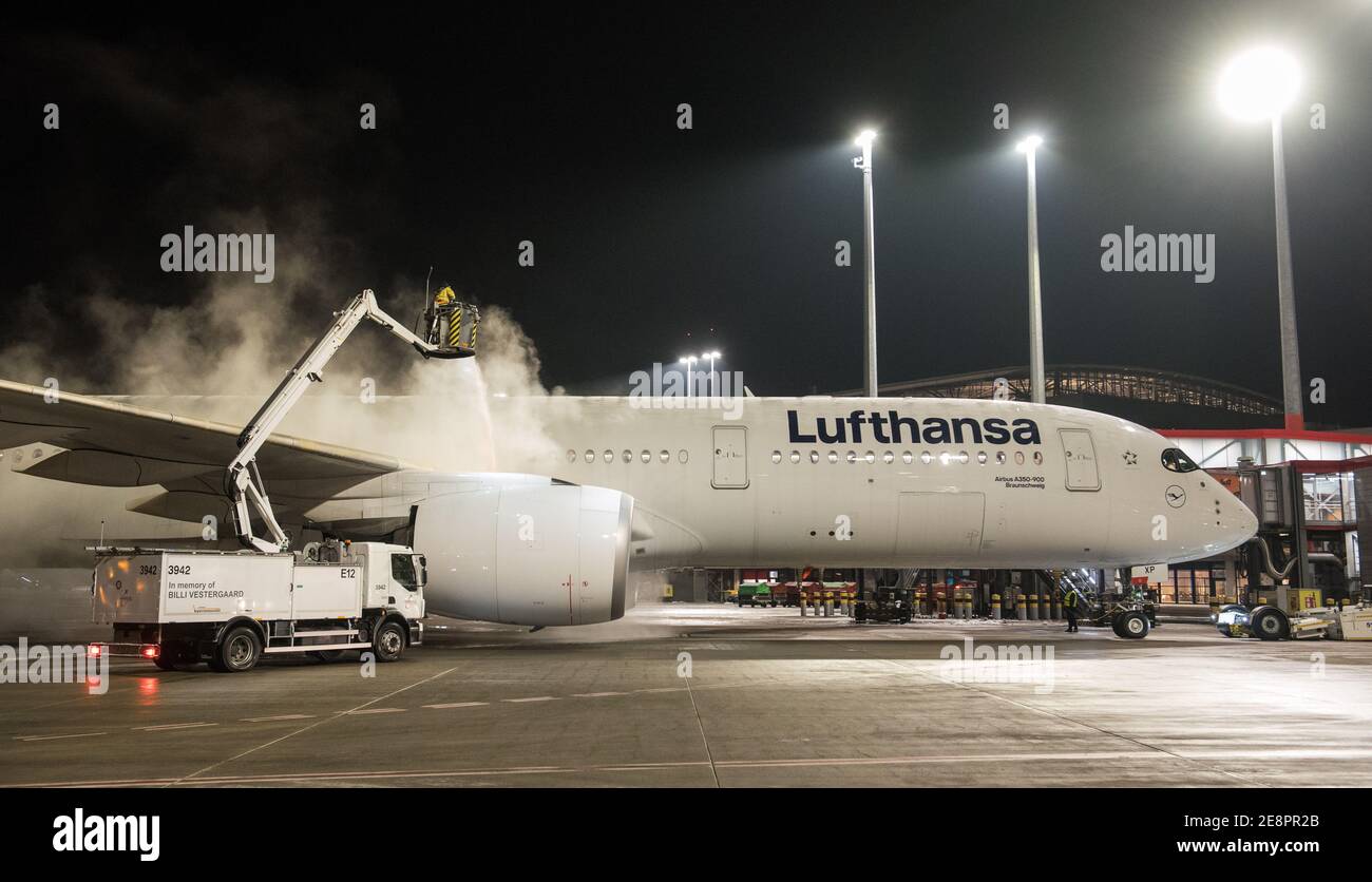 Hamburg, Germany. 31st Jan, 2021. A Lufthansa Airbus A350-900 aircraft is parked at Hamburg Airport this evening being de-iced. The aircraft has taken off on the longest non-stop passenger flight in Lufthansa's corporate history, its destination being the Mount Pleasant military base on the Falkland Islands 13,700 kilometres away. Credit: Daniel Bockwoldt/dpa/Alamy Live News Stock Photo