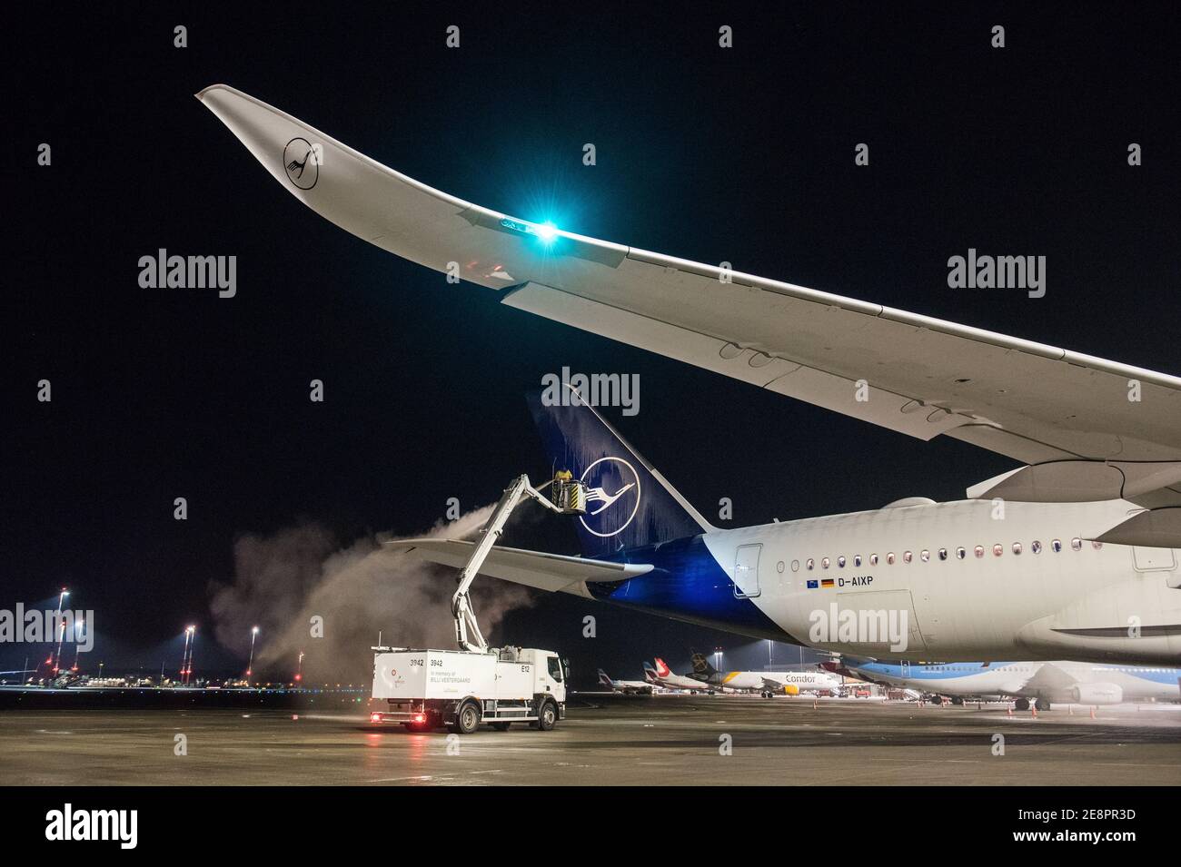 Hamburg, Germany. 31st Jan, 2021. A Lufthansa Airbus A350-900 aircraft is parked at Hamburg Airport this evening being de-iced. The aircraft has taken off on the longest non-stop passenger flight in Lufthansa's corporate history, its destination being the Mount Pleasant military base on the Falkland Islands 13,700 kilometres away. Credit: Daniel Bockwoldt/dpa/Alamy Live News Stock Photo