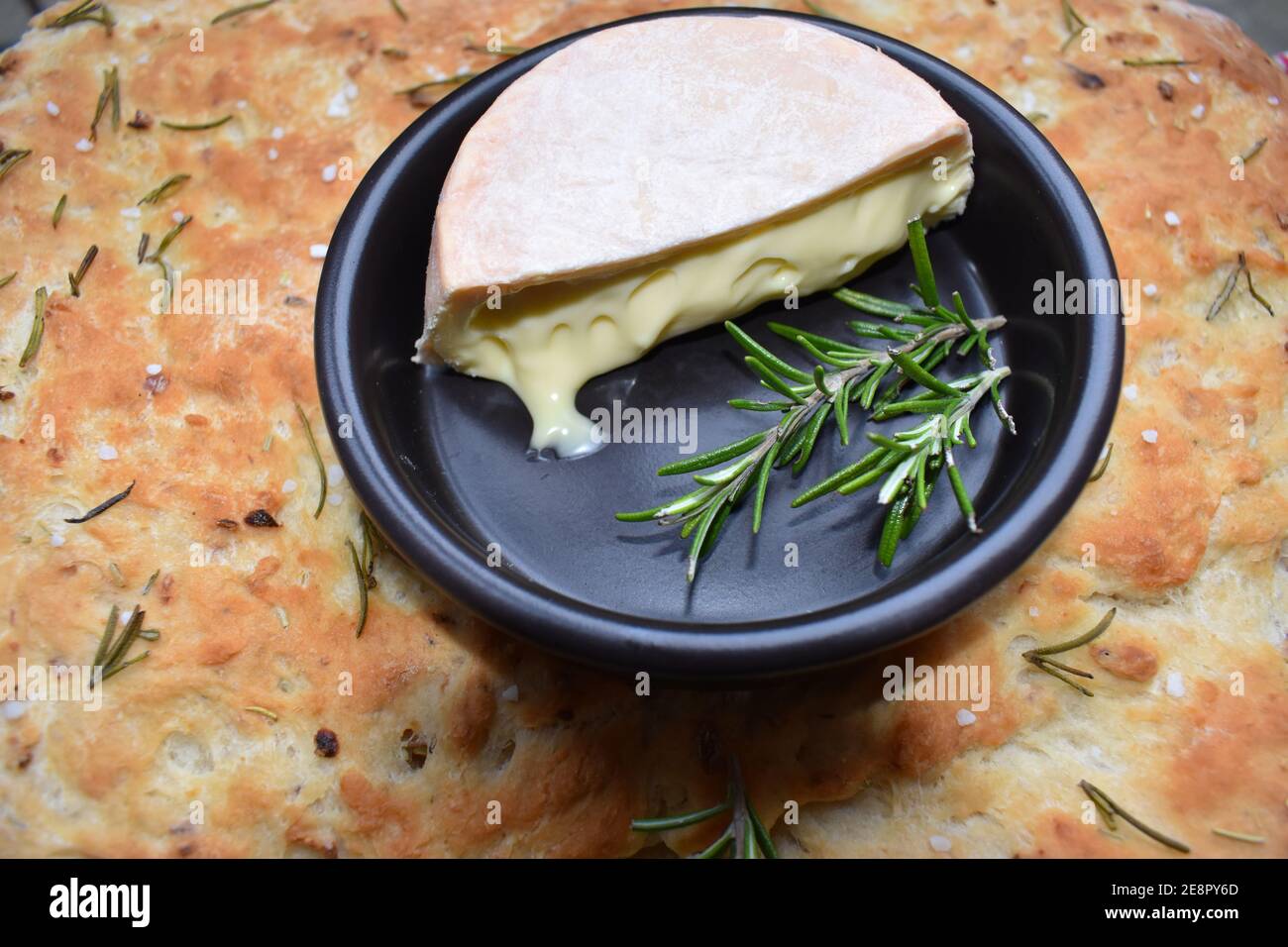 Focaccia is Italian flat bread flavoured with olive oil topped with salt and rosemary then baked and served with Welsh cider washed soft creamy cheese Stock Photo