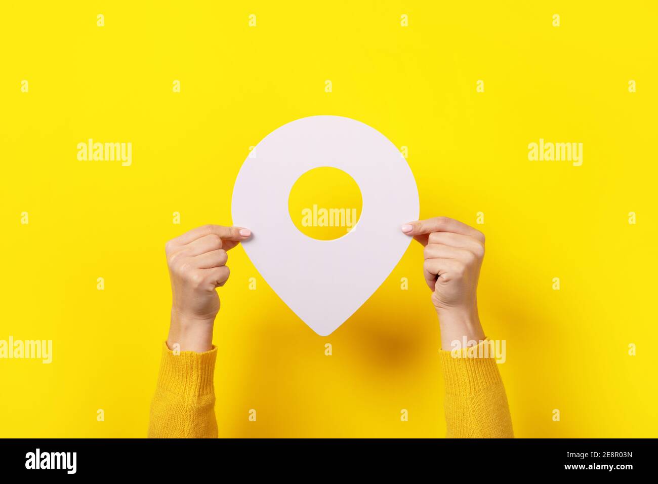 white map pointer 3d pin  in hand over yellow background Stock Photo