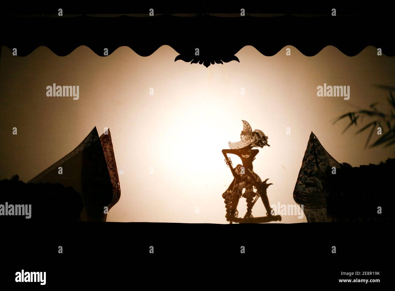 Indonesian puppet called wayang kulit performing on screen at night Stock Photo