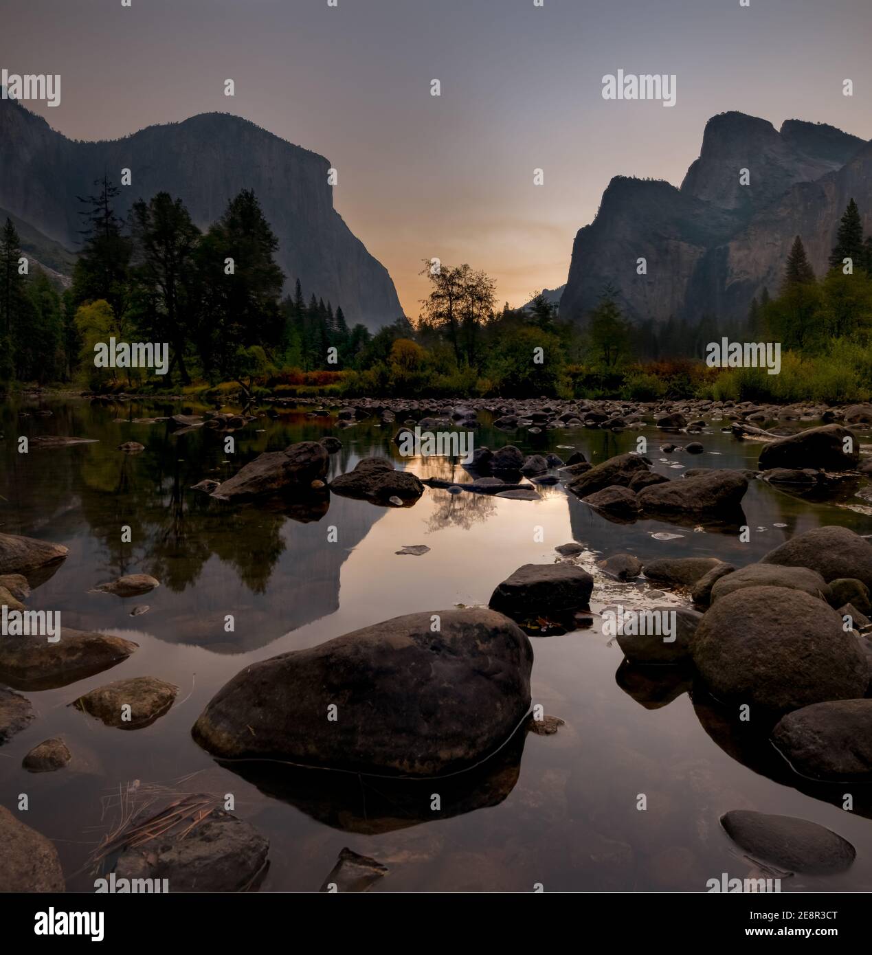 Sunrise at Yosemite Valley Viewpoint. Rocks in river foreground.  Stock Photo