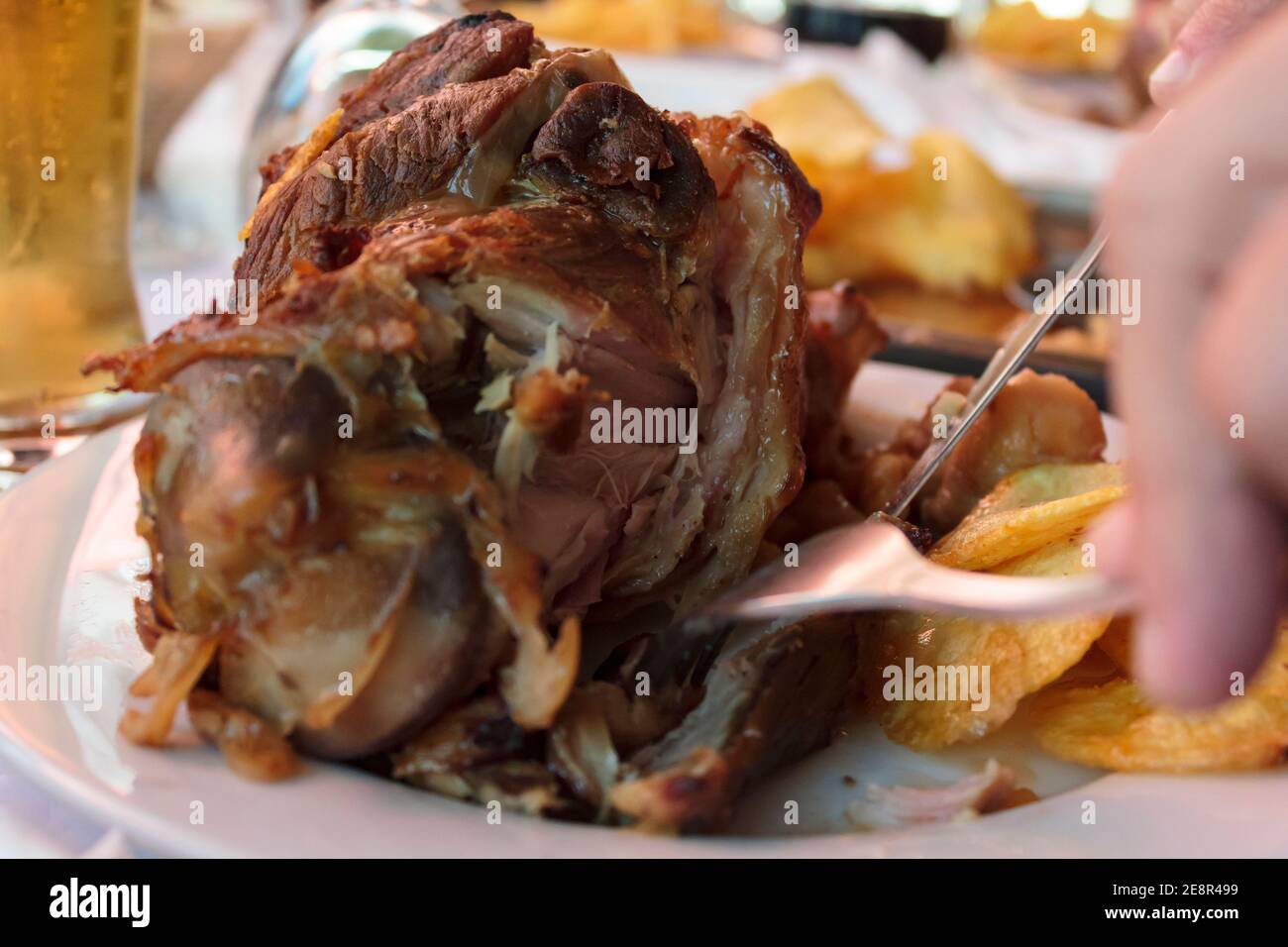 Eating roasted pork knuckle with french fries Stock Photo