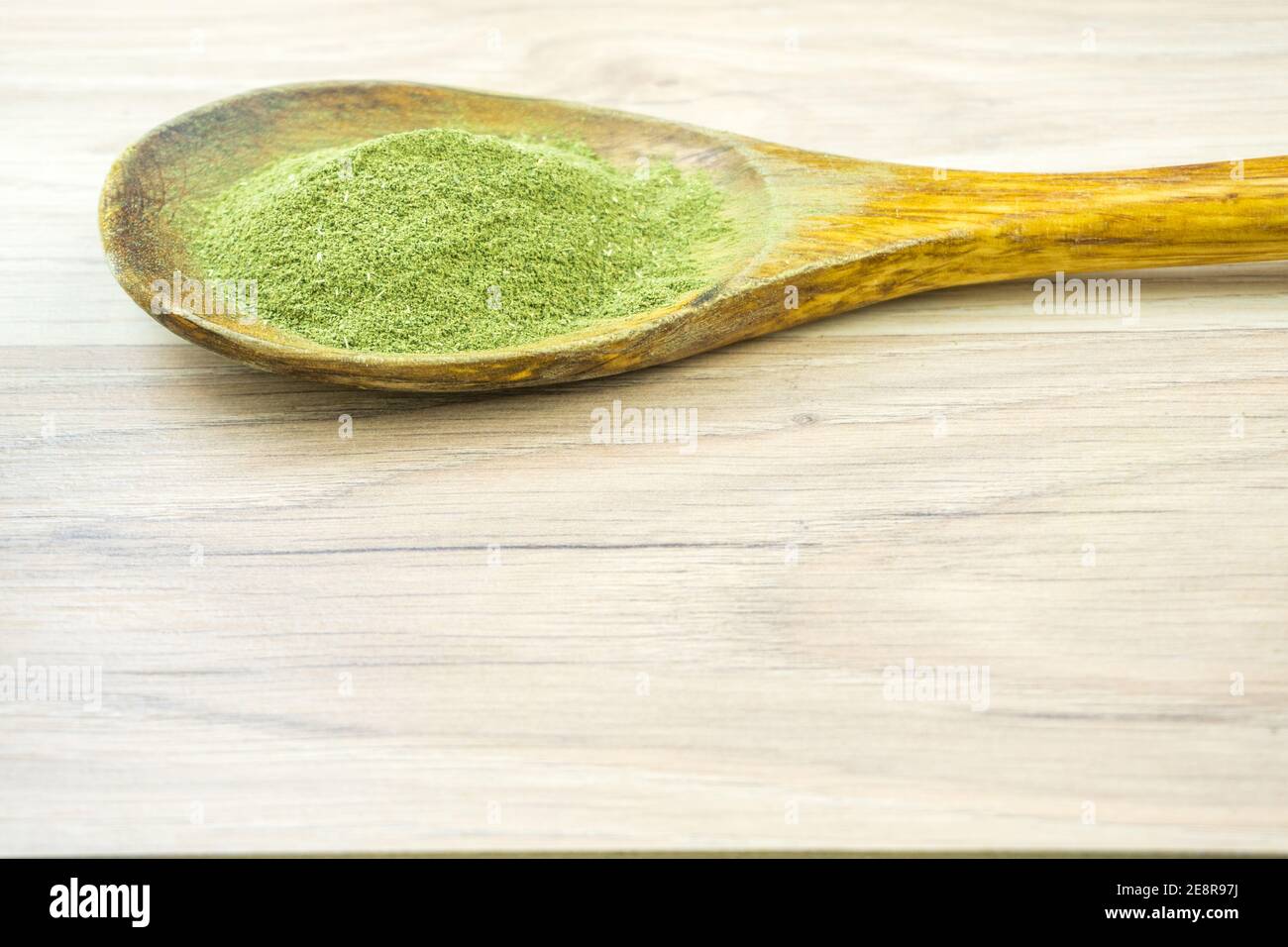 Kratom Mitragyna Speciosa an alternative medicine powder in wooden spoon with copy space Stock Photo